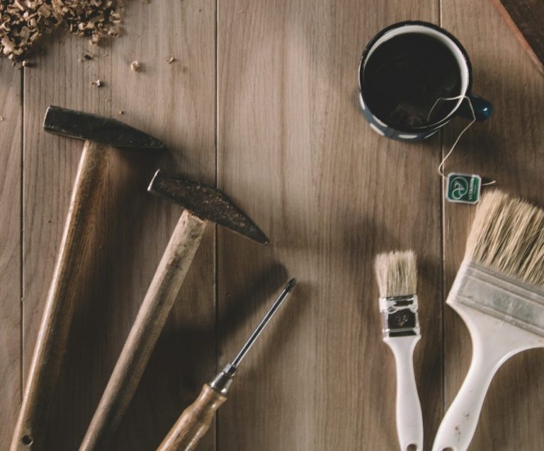 Werkzeuge, Handwerker Holzarbeiten Werkzeuge auf einem Tisch, einschließlich Hammer, Pinsel und Tasse. Handwerker. Handwerk. Reparaturen.